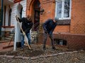 2 Männer entpflastern einen Vorgarten