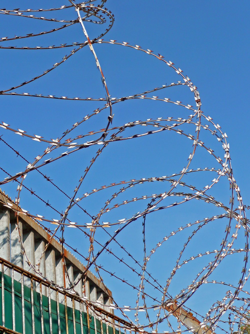 Stacheldraht – (c) Gabriele genannt Gabi Schoenemann - pixelio.de Maschendrahtzaun mit "NATO-Draht" und Überwachungskamera